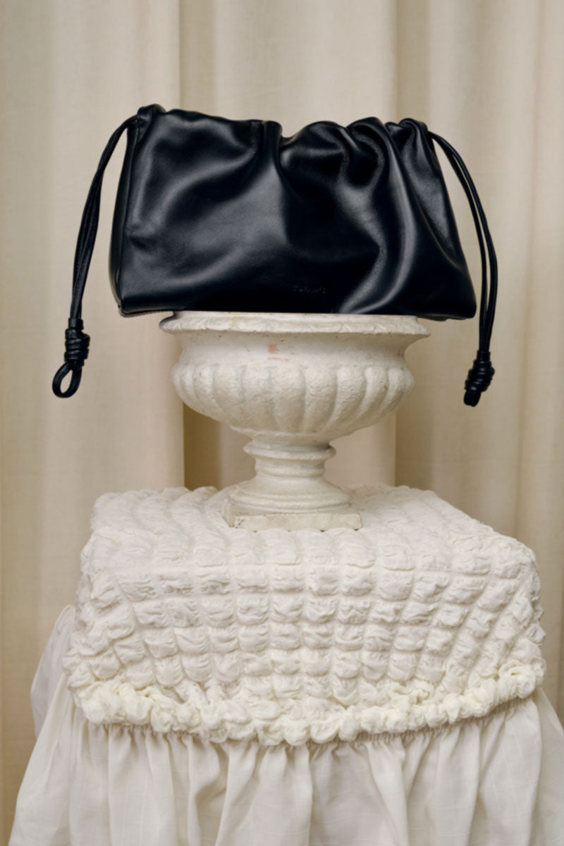 Black TUEAM'S Elora shoulder bag with sleek design and shoulder strap, stylish accessory for everyday use.