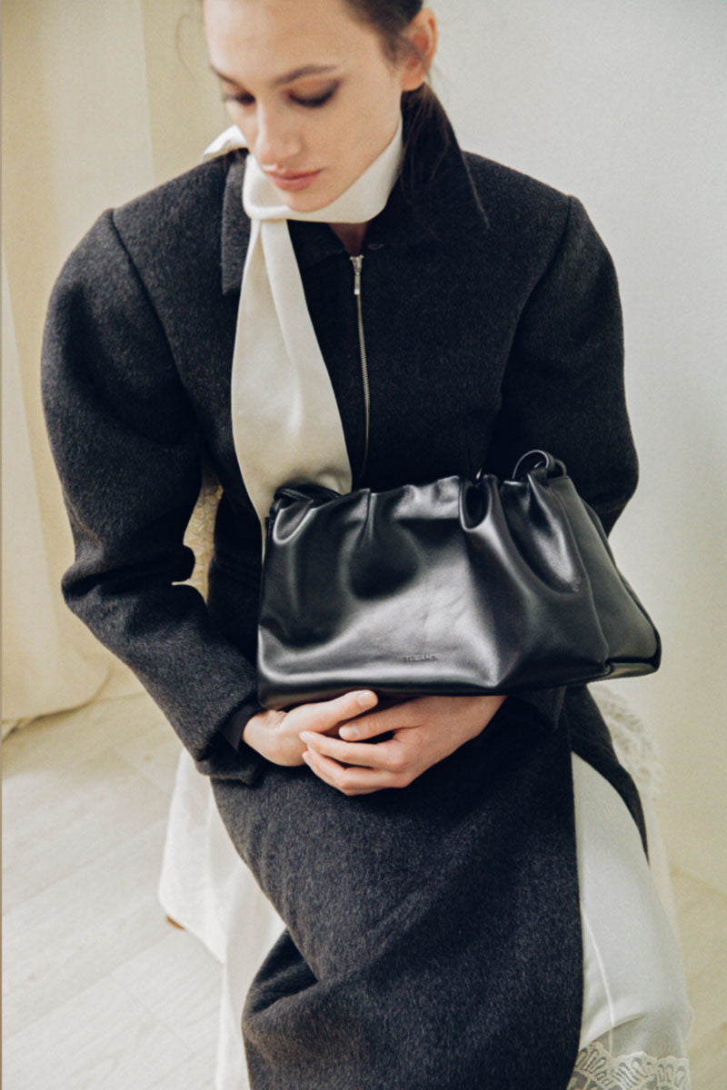 Black TUEAM'S Elora shoulder bag with sleek design and adjustable strap, perfect for everyday use.