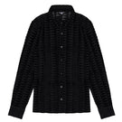 Black embossed tulle shirt by Bassigue, featuring textured fabric and a stylish, semi-sheer design on a model.