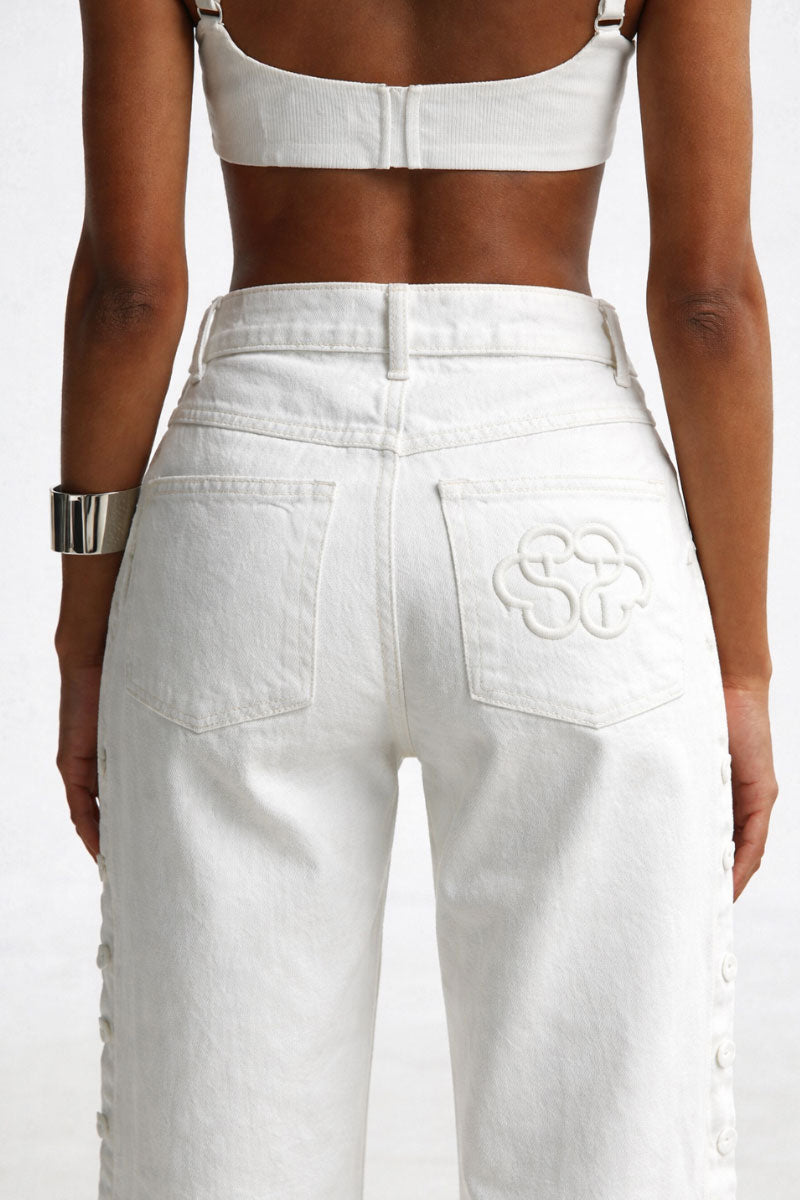 White embroidered jeans by Santa Brands featuring detailed stitching and classic denim texture.