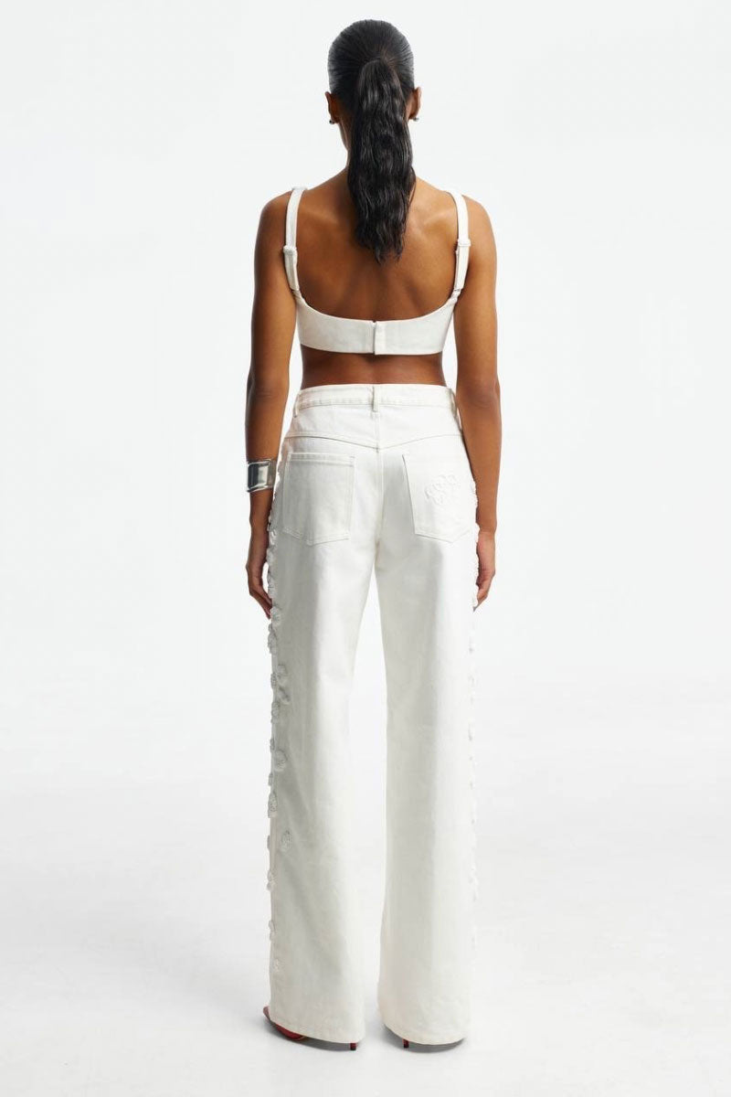 White embroidered jeans by Santa Brands showing detailed floral embroidery on the denim fabric.