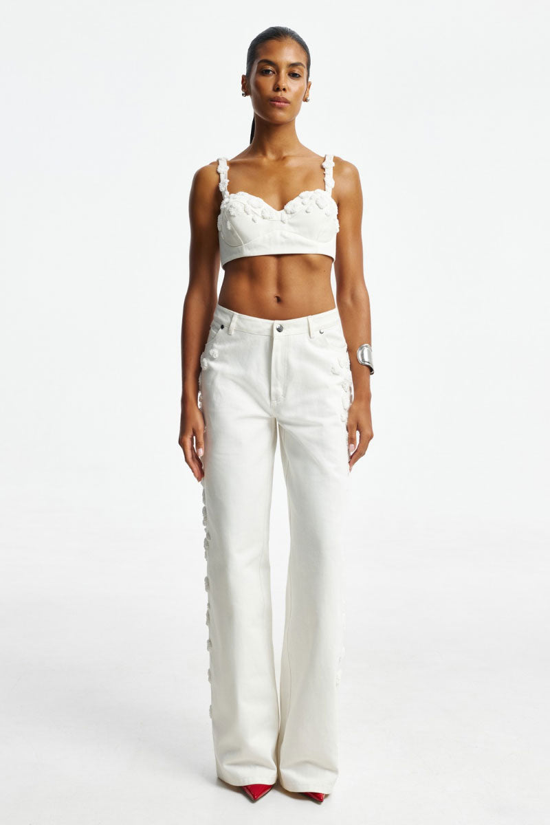 White embroidered jeans by Santa Brands, showcasing detailed floral embroidery on classic denim fabric.