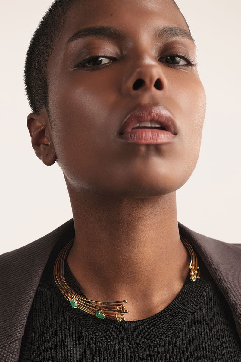 Gold emerald geo choker necklace by Fenomena, featuring a geometric design with vibrant green emerald accents.