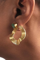 Gold earrings featuring open mini wave design with emerald accents from Fenomena.