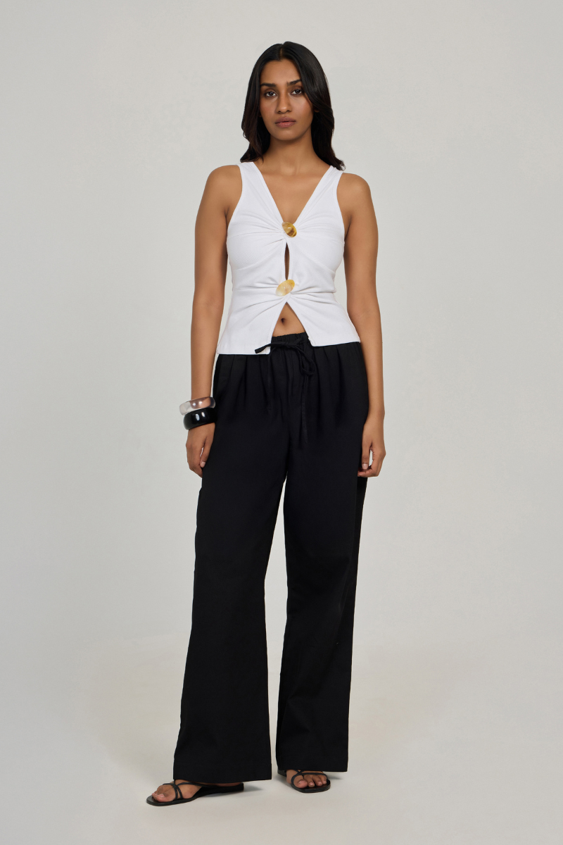 White Evia Top by Summer Away, stylish sleeveless blouse with a relaxed fit, displayed on a hanger against a neutral background.
