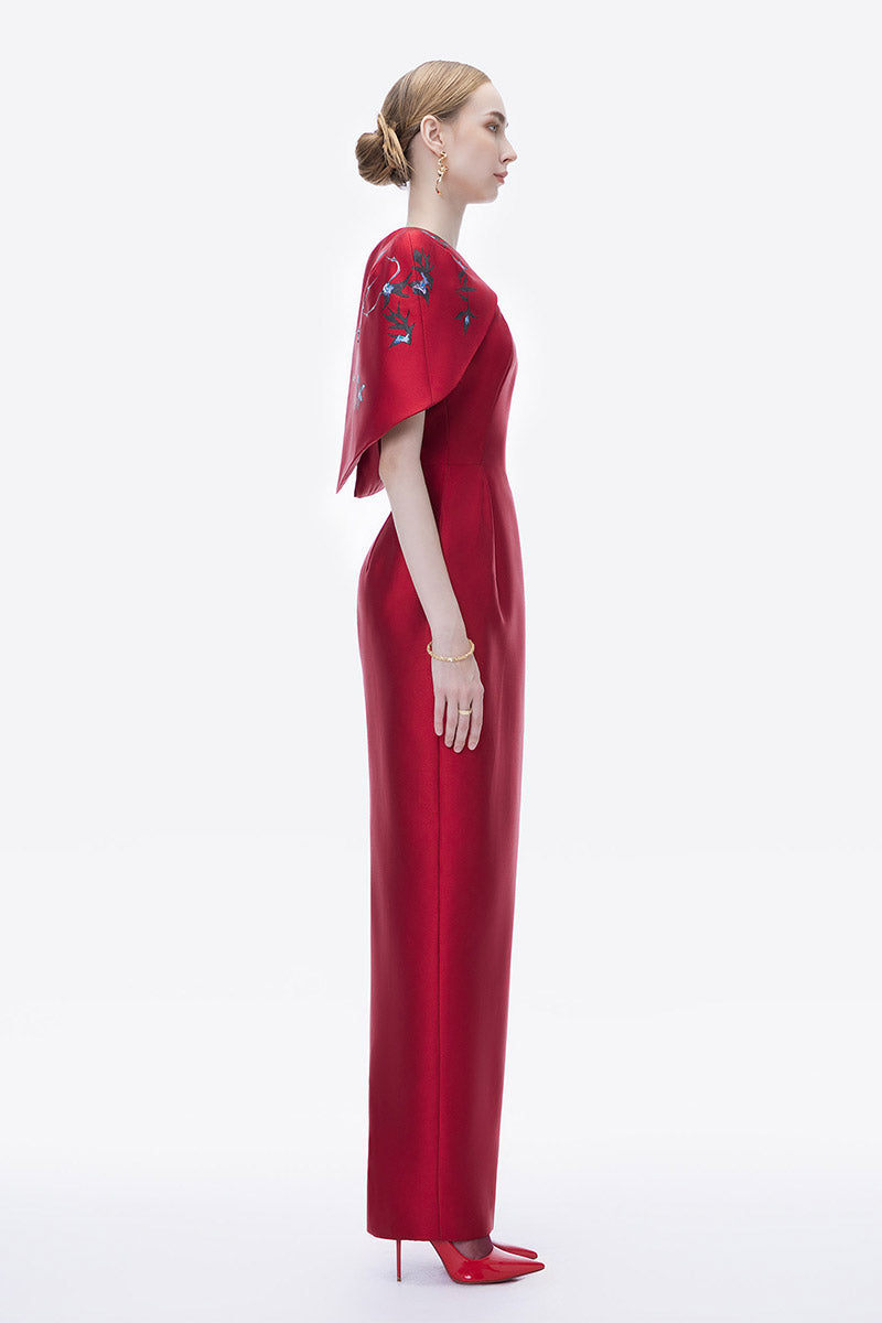 Hand-painted crimson cosmos gown by Tiny Ink featuring flowing fabric and intricate celestial designs for elegant evening wear.