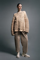 Ivory flat braided knitted sweater with accordion sleeves by MAZ Manuela Álvarez, showcasing textured knit and stylish design.