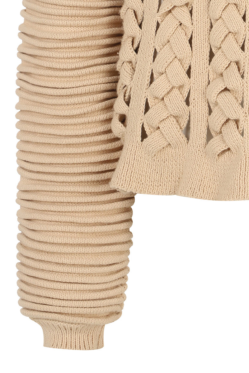 Ivory flat braided knitted sweater with accordion sleeves by MAZ Manuela Álvarez, showcasing textured knit and stylish design.