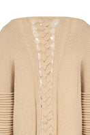 Ivory flat braided knitted sweater with accordion sleeves by MAZ Manuela Álvarez, styled with a cozy, textured look.