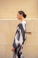 Black printed Tinta Latina Floresta maxi dress displayed on a model, showcasing its flowing fabric and stylish design.