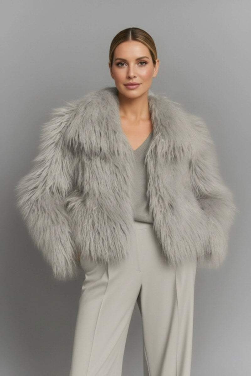 Gray fluffy faux fur jacket by Fortini, shown on a hanger with soft plush texture and cozy style.