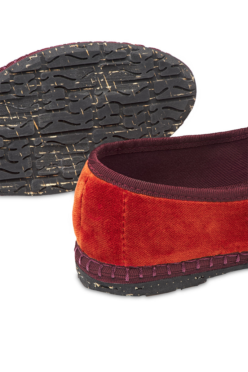 Red-orange velvet flats with burgundy piping by Flabelus, featuring a classic Mary Jane style and elegant design.
