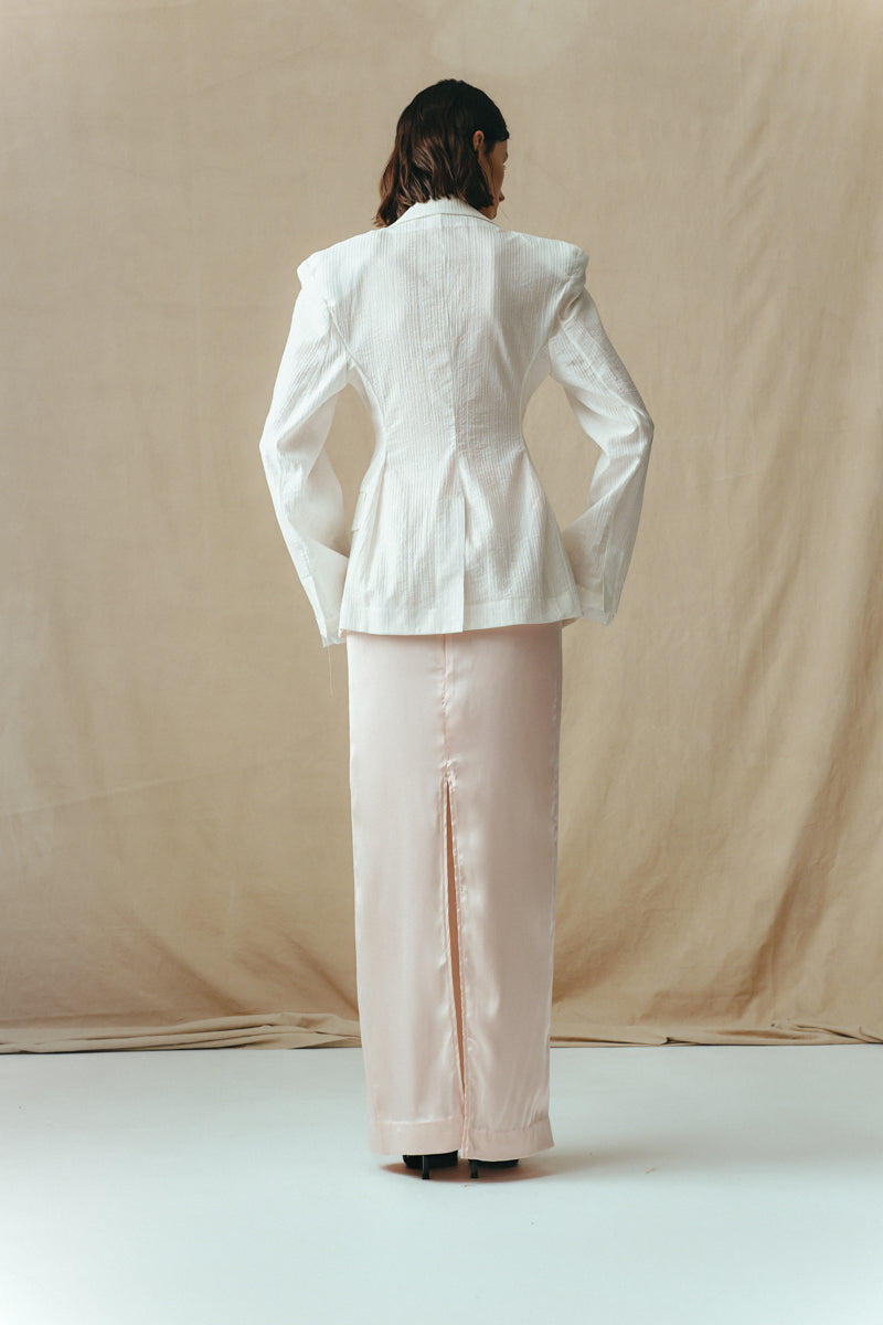 Back view of Sean Sheila satin maxi skirt in blush, flowing floor-length skirt with smooth, shiny fabric and elegant silhouette.