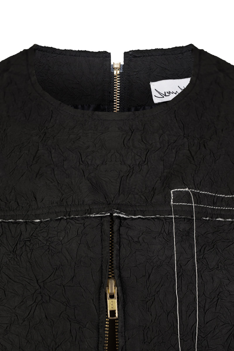 Black crinkled top by Sean Sheila, showcasing textured fabric and stylish design, perfect for casual or chic outfits.