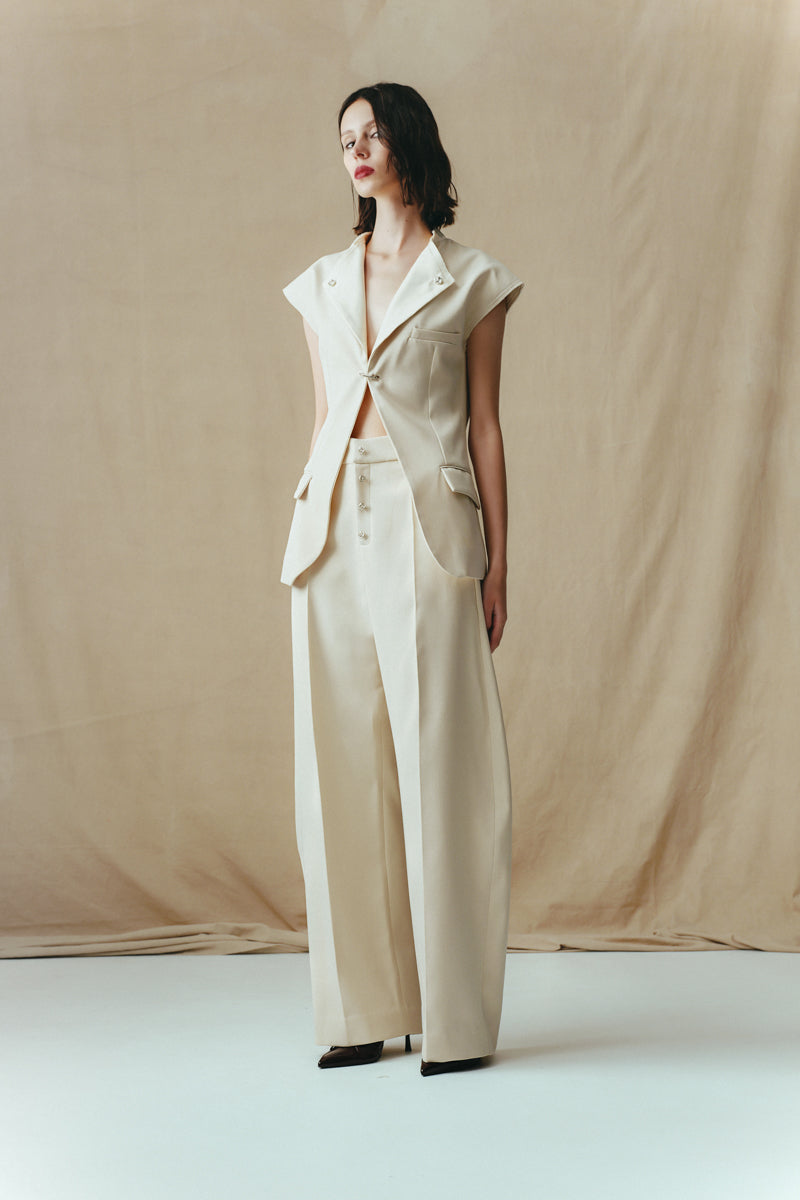 Eggshell vest with single hook detail from Sean Sheila, stylish sleeveless top shown from side view.