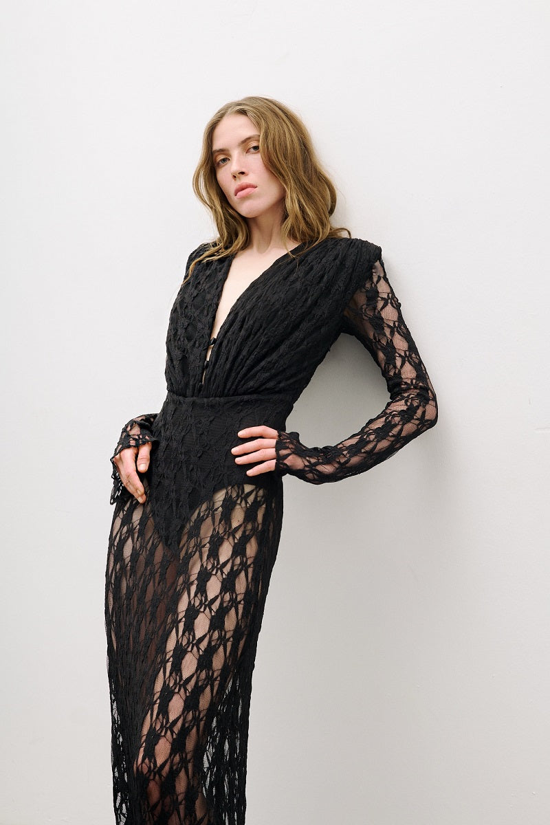 Black long-sleeved maxi dress by AWAVE, flowing fabric, fitted waist, and elegant design, shown on a model.