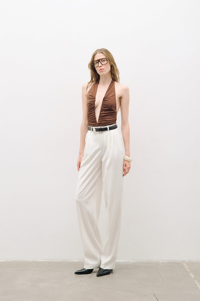 White double-pleated wide-leg pants from AWAVE, shown laid flat to display their flowy fabric and high waist design.