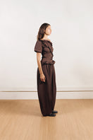 YASSMIN SALEH brown falling pants shown from the back, featuring a relaxed fit and stylish drape for casual wear.