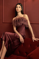 Manito Fiesta Feather long gown in burgundy red, featuring flowing silk fabric and elegant feather detailing.