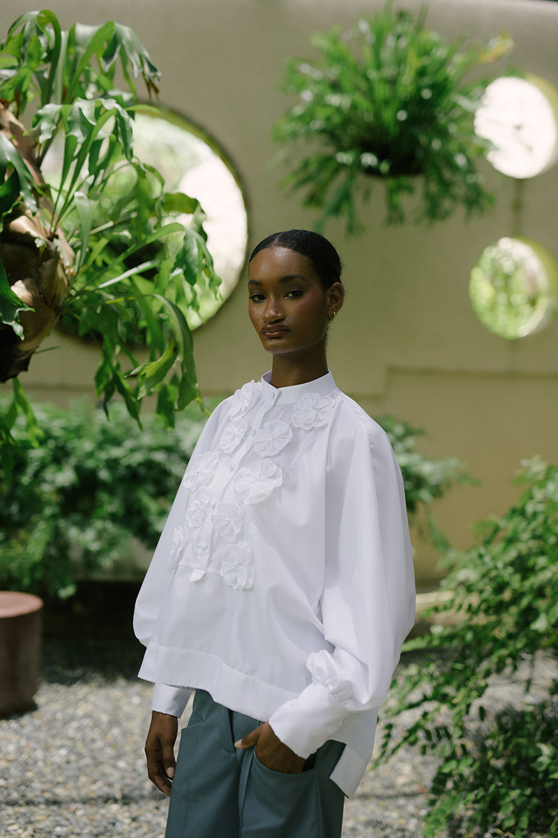 White Fiora top by Ana + Maria, featuring a stylish design, displayed on a model in a campaign photo.