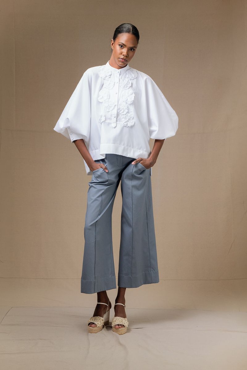 White Fiora top by ANA + MARIA, showcased on a model, featuring a stylish, lightweight design perfect for casual or chic outfits.