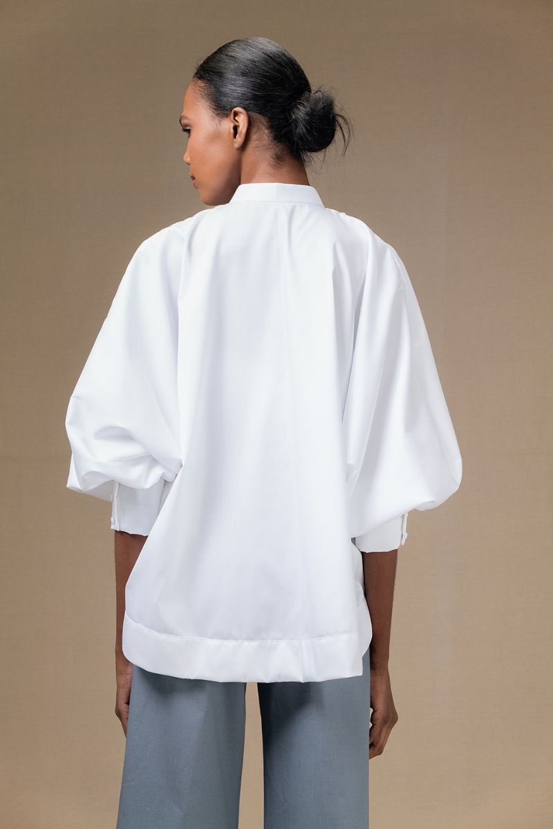 White Fiora top by ANA + MARIA, shown on a model, featuring a stylish, fitted design perfect for casual or dressy occasions.