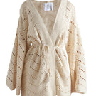 First Born Knits Mia cardigan displayed on a hanger, showcasing soft knit fabric and stylish design.