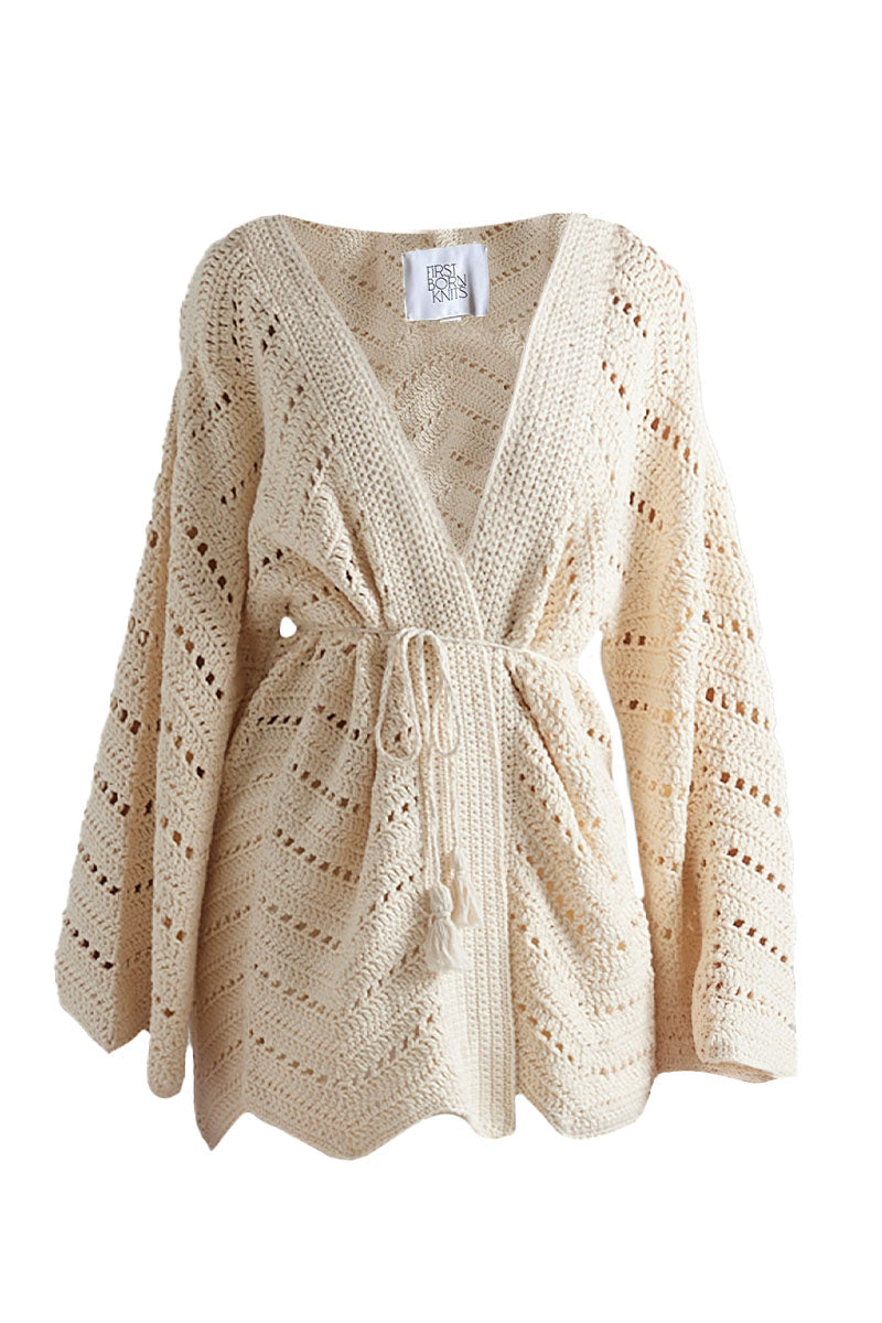 First Born Knits Mia cardigan displayed on a hanger, showcasing soft knit fabric and stylish design.