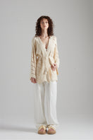 Cream-colored MIA cardigan by First Born Knits, featuring a soft knit texture and relaxed fit, displayed on a neutral background.