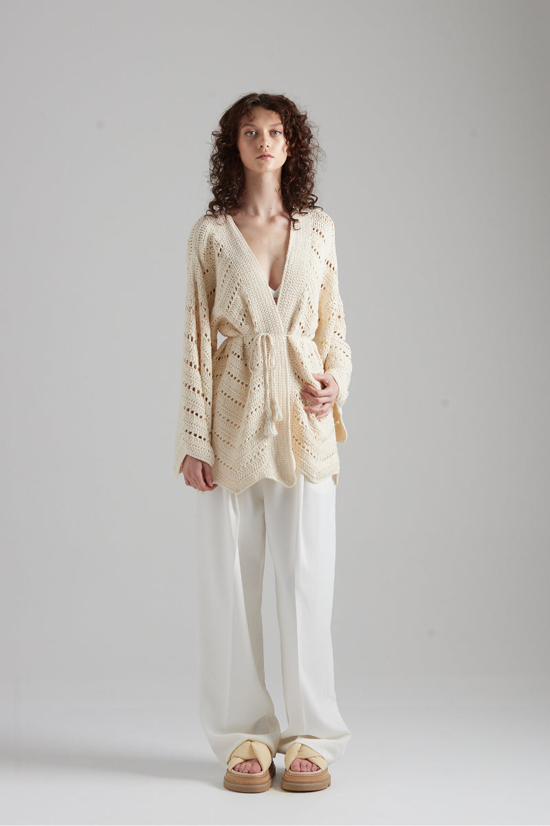Cream-colored MIA cardigan by First Born Knits, featuring a soft knit texture and relaxed fit, displayed on a neutral background.