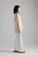 First Born Knits CELINE polo top in neutral color, featuring a classic collar and ribbed cuffs, displayed on a hanger.