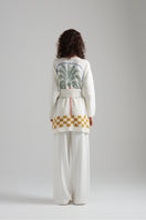 First Born Knits LA PALME cardigan featuring soft fabric and stylish design, worn by a model in a cozy indoor setting.