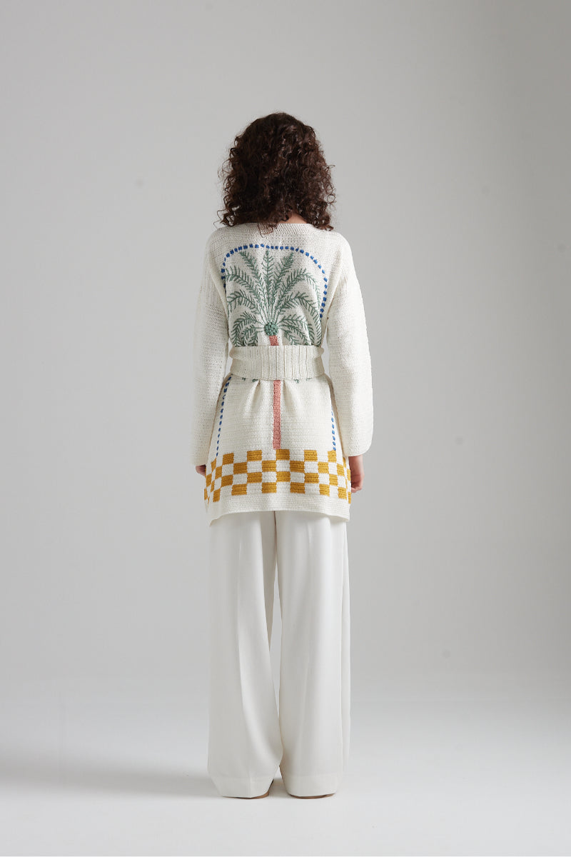 First Born Knits LA PALME cardigan featuring soft fabric and stylish design, worn by a model in a cozy indoor setting.