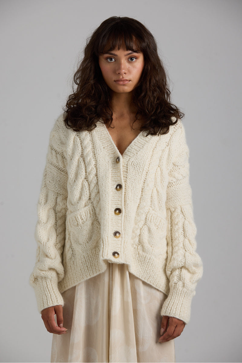 Light pink First Born Knits Paris Cardigan with long sleeves and button closure, soft knit fabric, and classic design.