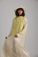 Cream-colored Tierra Vest knitwear by First Born Knits, featuring a cozy, textured design and ribbed neckline.
