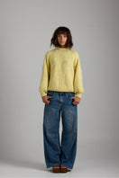 Cream-colored shell sweater from First Born Knits featuring a cozy knit design and ribbed cuffs.