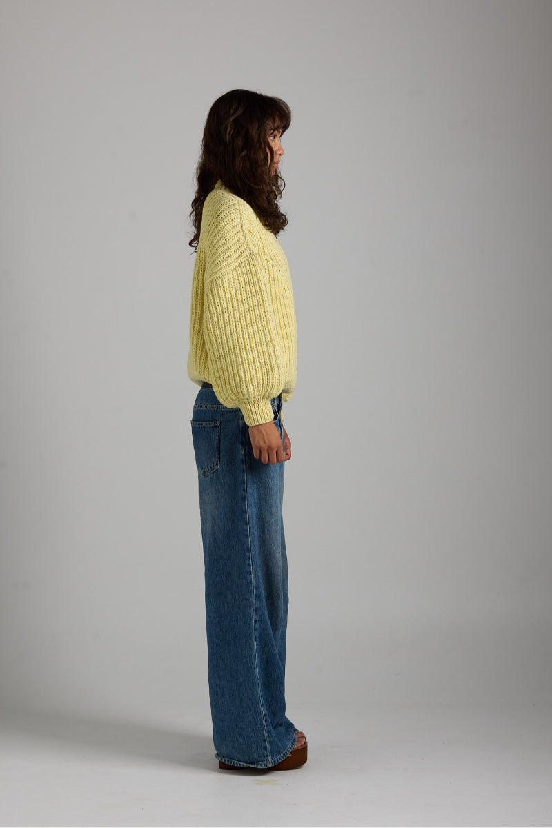 Cream-colored shell sweater by First Born Knits, featuring a cozy knit design and ribbed cuffs, perfect for casual wear.