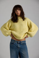 Cream-colored Shell Sweater from First Born Knits featuring a cozy, textured knit pattern and ribbed cuffs.