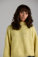Cream-colored shell sweater from First Born Knits, featuring a cozy, textured knit design and a relaxed fit.
