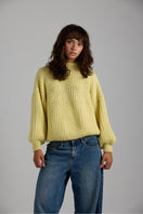 First Born Knits shell sweater featuring a cozy, textured knit design in neutral tones, perfect for casual wear.
