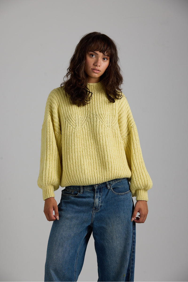 First Born Knits shell sweater featuring a cozy, textured knit design in neutral tones, perfect for casual wear.