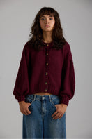 Cream-colored Frenchie cardigan by First Born Knits, featuring soft knit fabric and classic button details.
