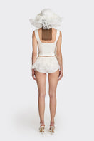 Off-white fitted corset bustier top by Stolen Stores, form-fitting design with structured detailing and adjustable straps.