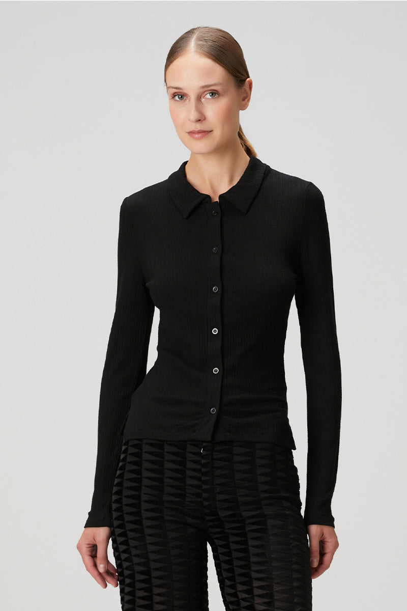Black fitted rib button-down shirt by Bassigue, showing a close-up of the tailored collar and sleek fabric texture.