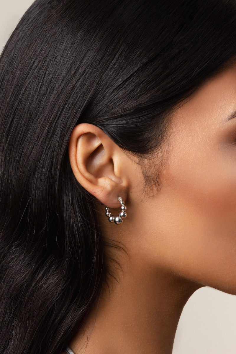 Silver hoop earrings by Sara Shala with a sleek, minimalist design, shown on the model for stylish everyday wear.