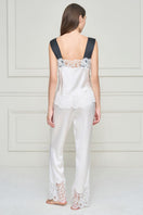 Woman wearing white silk lace flapper-style pajama set by MANITO, featuring elegant lace details and a comfortable fit.