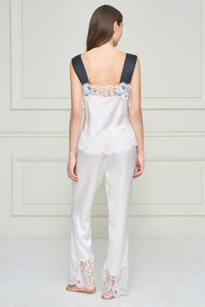 Woman wearing white silk lace flapper-style pajama set by MANITO, featuring elegant lace details and a comfortable fit.