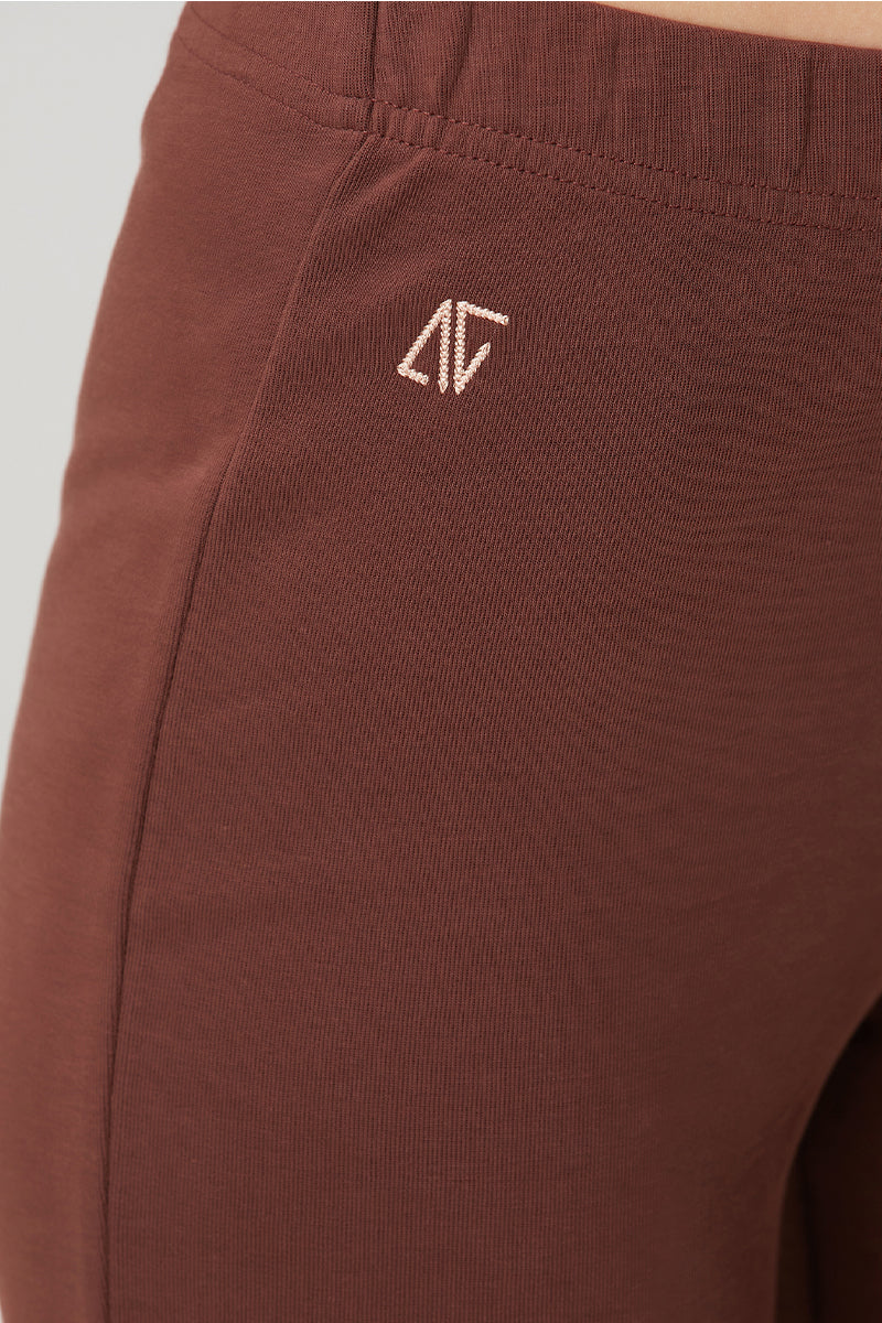 Brown flare sweatpants by Bassigue, shown on a hanger with a relaxed fit and elastic waistband, casual and stylish for everyday wear.