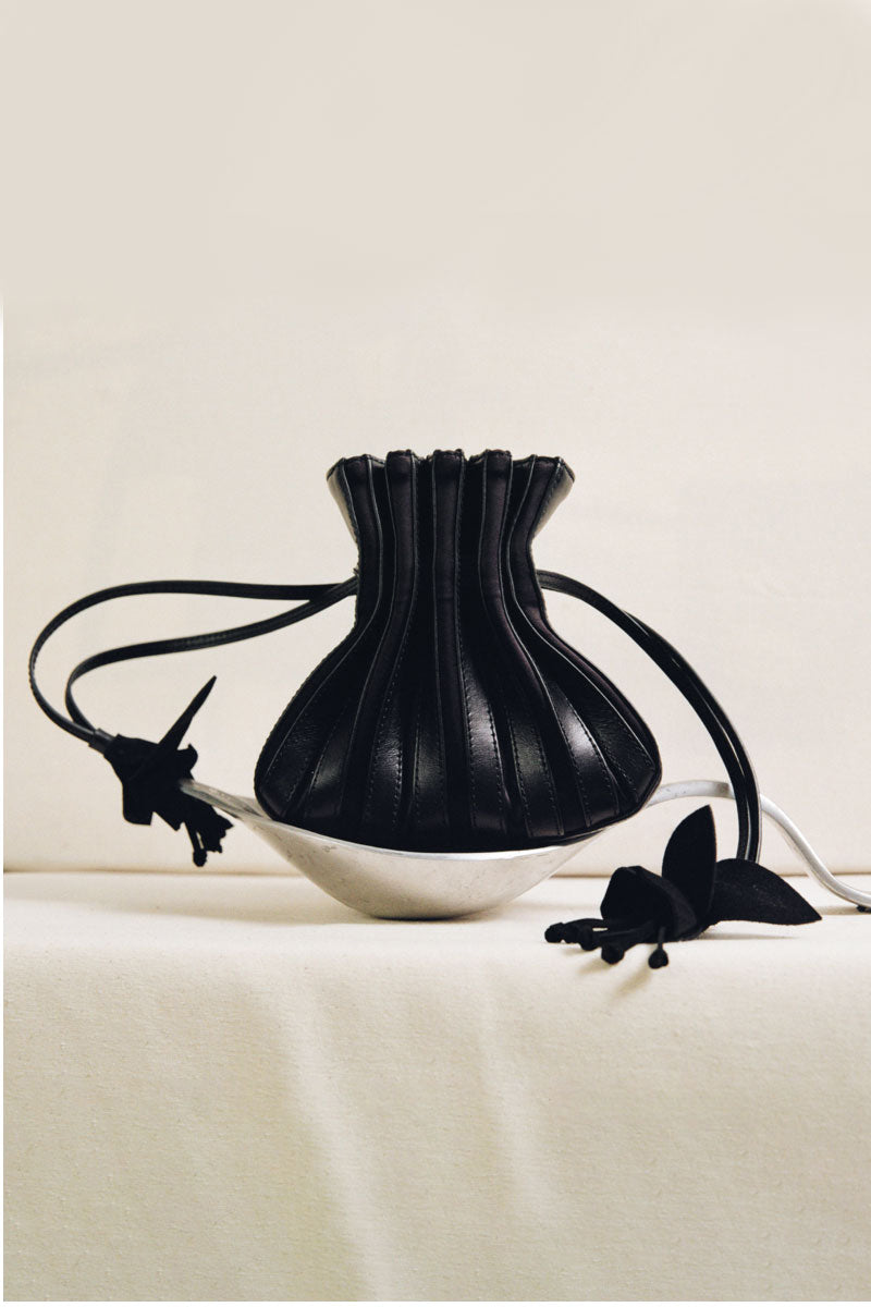 Black TUEAM'S Fleur bag with top handle and elegant design, showcasing its stylish and versatile accessory features.