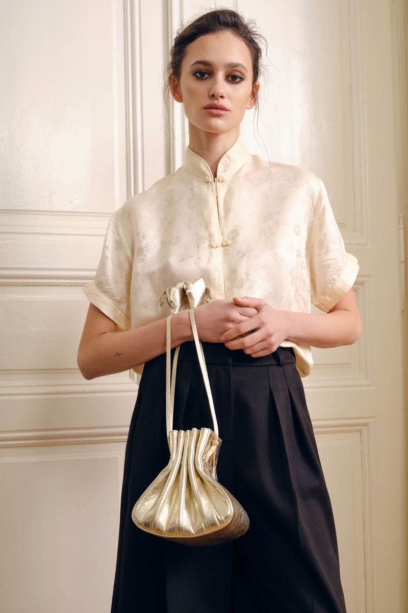 TUEAM'S Fleur Bag in Gold, a stylish top handle bag with elegant gold finish and floral-inspired design.